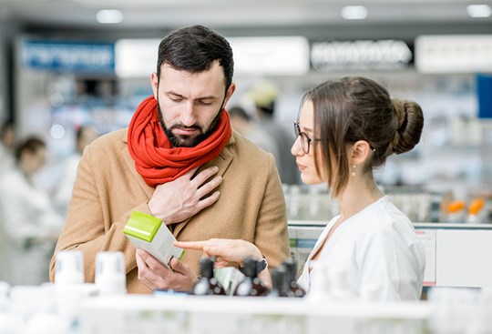 Mann kauft Medikamente in einer Apotheke