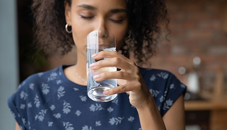 Eine Frau trinkt ein Glas Wasser