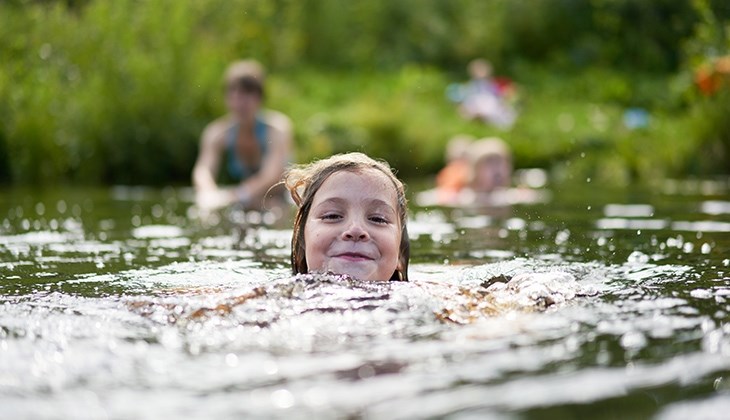 Ein Kind ist im See schwimmen