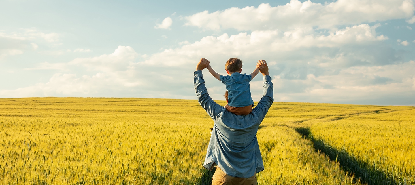 Vater und Kind stehen in einem Weizenfeld