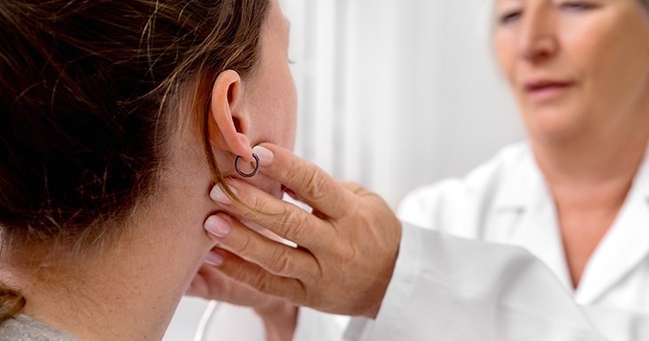 Eine Ärztin untersucht eine Patientin und tastet den Hals ab