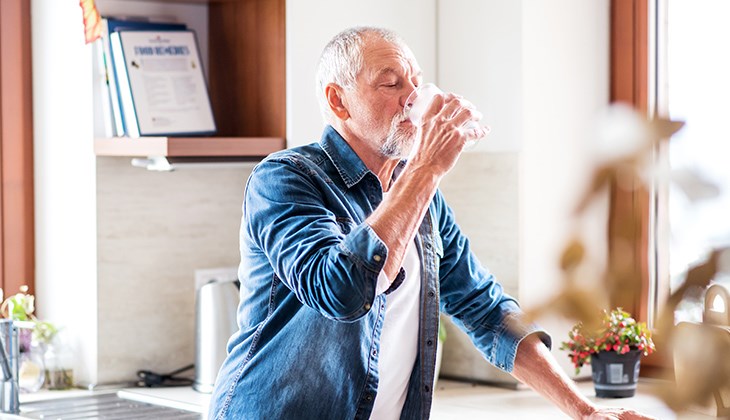 Ein Mann trinkt ein Glas Wasser
